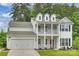 Charming two-story home with inviting double porch, manicured lawn, and attached two-car garage at 7209 Brookline Pl, Huntersville, NC 28078
