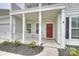 Inviting front porch with red front door and manicured landscaping at 7209 Brookline Pl, Huntersville, NC 28078