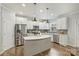 Bright kitchen featuring stainless appliances, white cabinets, a center island and durable hard surface countertops at 7209 Brookline Pl, Huntersville, NC 28078