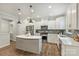 Modern kitchen with stainless appliances, gray island, white cabinets and lots of lighting at 7209 Brookline Pl, Huntersville, NC 28078