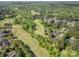 Expansive aerial view showcasing the golf course community surrounded by mature trees and upscale homes at 7280 Woodside Ct, Denver, NC 28037