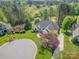 An aerial view showcasing this stunning property with mature trees, lush landscaping, and well manicured lawn at 7280 Woodside Ct, Denver, NC 28037