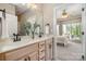 Bright bathroom with double vanity, wooden cabinets, and a glimpse of the bedroom at 7280 Woodside Ct, Denver, NC 28037