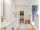 Bright bathroom with double vanity, walk-in shower with blue tile accent, and walk-in closet at 7280 Woodside Ct, Denver, NC 28037