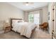Cozy bedroom with ceiling fan, neutral decor, a comfy chair and natural light from the window at 7280 Woodside Ct, Denver, NC 28037