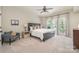 Spacious bedroom with ceiling fan, carpeting, and ample natural light from the large windows at 7280 Woodside Ct, Denver, NC 28037