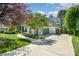 Charming exterior view of a white-painted home with a modern garage door, curved driveway, and manicured landscaping at 7280 Woodside Ct, Denver, NC 28037