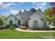 Beautiful single-story home showcasing a lush lawn, walkway, black trim windows and colorful landscaping at 7280 Woodside Ct, Denver, NC 28037