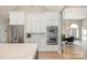 Bright kitchen with stainless steel appliances, white cabinets, marble countertops and barstool seating at 7280 Woodside Ct, Denver, NC 28037