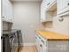 Well-organized laundry room with butcher block countertop and modern washer and dryer units at 7280 Woodside Ct, Denver, NC 28037