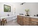 Modern bathroom with soaking tub under a window, wood vanity, and sleek fixtures at 816 Tennyson Dr, Charlotte, NC 28208