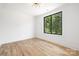 Bright bedroom with hardwood floors and a large window overlooking a green, tree-filled backyard at 816 Tennyson Dr, Charlotte, NC 28208