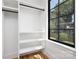 Organized closet space with built-in shelving and a window overlooking a tree lined view at 816 Tennyson Dr, Charlotte, NC 28208