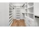Walk-in closet with custom shelving, drawers, and hardwood floors for ample storage space at 816 Tennyson Dr, Charlotte, NC 28208