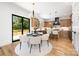 Bright dining area with modern chandelier, access to the deck, and a view into the kitchen at 816 Tennyson Dr, Charlotte, NC 28208