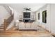 Bright living room with a black fireplace, neutral furniture, hardwood floors, and large windows at 816 Tennyson Dr, Charlotte, NC 28208