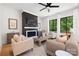 Cozy living room features a fireplace, neutral decor, a ceiling fan, and bright, natural lighting at 816 Tennyson Dr, Charlotte, NC 28208