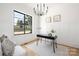 Modern home office with a black minimalist desk, white wainscoting, hardwood floors and a large window at 816 Tennyson Dr, Charlotte, NC 28208