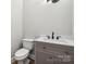 Stylish half bathroom featuring a modern vanity with marble countertop and sleek fixtures at 817 Quince Ct, Indian Trail, NC 28079