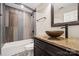Bathroom featuring a granite vanity, bowl sink, decorative mirror, and a tiled shower-tub at 817 Quince Ct, Indian Trail, NC 28079