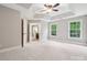 Neutral bedroom with tray ceilings, a ceiling fan, soft carpeting, and access to the en-suite bathroom at 817 Quince Ct, Indian Trail, NC 28079