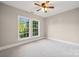 Bright bedroom featuring carpet, neutral colors, and a window overlooking mature trees at 817 Quince Ct, Indian Trail, NC 28079
