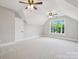 Spacious bedroom featuring carpet, neutral colors, ceiling fans and a window overlooking mature trees at 817 Quince Ct, Indian Trail, NC 28079