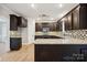Stylish kitchen with granite countertops, dark wood cabinets, and stainless steel appliances at 817 Quince Ct, Indian Trail, NC 28079