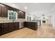 Modern kitchen with dark wood cabinets, granite countertops, and stainless steel dishwasher at 817 Quince Ct, Indian Trail, NC 28079