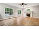 Spacious living room with large windows, hardwood floors, a ceiling fan, and a classic fireplace at 817 Quince Ct, Indian Trail, NC 28079