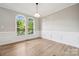 Inviting living room with hardwood floors, stylish wainscoting, and lots of natural light through large windows at 817 Quince Ct, Indian Trail, NC 28079