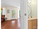 Bathroom featuring hardwood floors, updated vanity, framed mirror, and adjacent sunroom access at 9101 Strattonville Ct, Huntersville, NC 28078