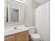 Bathroom featuring toilet, wood-stained vanity, and shower with white curtain at 9101 Strattonville Ct, Huntersville, NC 28078
