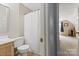 Updated bathroom featuring toilet, wood-stained vanity, and shower with white curtain at 9101 Strattonville Ct, Huntersville, NC 28078