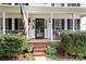 Charming home entrance with American flag, potted plants, and a cozy porch at 9101 Strattonville Ct, Huntersville, NC 28078