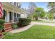 Brick steps lead to a covered porch with nice landscaping and lawn at 9101 Strattonville Ct, Huntersville, NC 28078