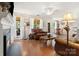 Open-concept living room with fireplace, windows, ceiling fan, and hardwood floors at 9101 Strattonville Ct, Huntersville, NC 28078