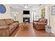 Comfortable living room featuring hardwood floors, fireplace, ceiling fan, and natural lighting at 9101 Strattonville Ct, Huntersville, NC 28078