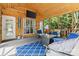Relax on the screened porch with wood paneled walls and ceiling and a blue patterned rug at 9101 Strattonville Ct, Huntersville, NC 28078