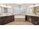 Bathroom with a corner soaking tub, and vanities and tile floors at 10201 Daufuskie Dr, Charlotte, NC 28278