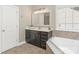 Well-lit bathroom featuring dark wood cabinetry, white countertop and large soaking tub at 10201 Daufuskie Dr, Charlotte, NC 28278