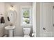 Half bathroom with modern sink, toilet, and a window at 10201 Daufuskie Dr, Charlotte, NC 28278