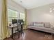 Bright home office featuring hardwood floors, dual monitors, and a comfortable couch at 10201 Daufuskie Dr, Charlotte, NC 28278
