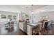 Open kitchen with island seating, stainless steel dishwasher and view into living space at 10201 Daufuskie Dr, Charlotte, NC 28278