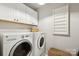 Laundry room with white cabinets and side-by-side washer and dryer at 10201 Daufuskie Dr, Charlotte, NC 28278