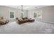 Spacious living room with a large sectional couch and three bright windows at 10201 Daufuskie Dr, Charlotte, NC 28278