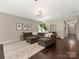 Open living room with a large sectional sofa, modern decor, and hardwood floors at 10201 Daufuskie Dr, Charlotte, NC 28278