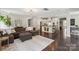 Open-concept living room with a modern chandelier, cozy sofa, and a view of the kitchen at 10201 Daufuskie Dr, Charlotte, NC 28278