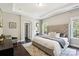Comfortable main bedroom with tufted headboard, trey ceiling, hardwood floors, and large windows at 10201 Daufuskie Dr, Charlotte, NC 28278