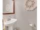 Powder room features a pedestal sink, mirror, and decorative wall art at 10508 Madison Park Dr, Charlotte, NC 28269